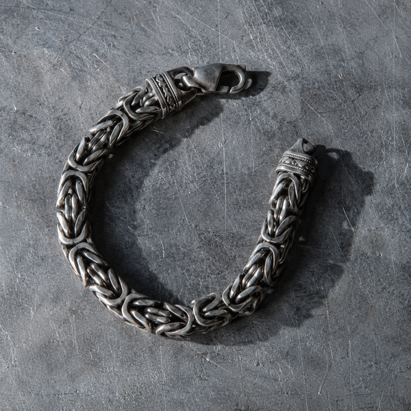 A heavy woven Byzantine bracelet in an open curve