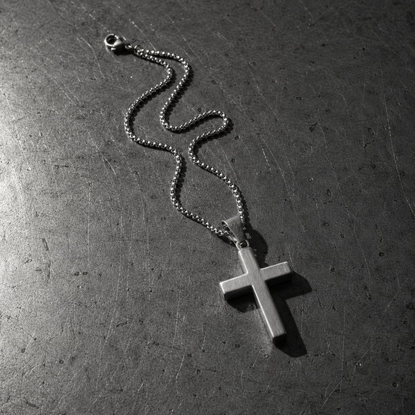 A steel cross pendant on a box chain